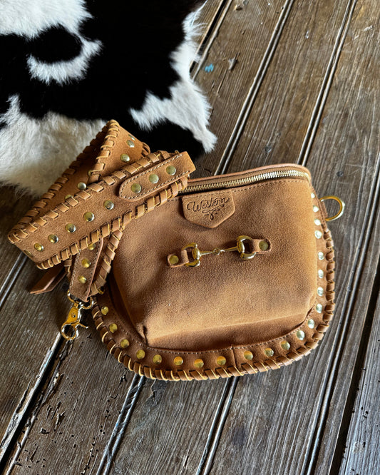 Brown leather pouch with studs on a wooden surface