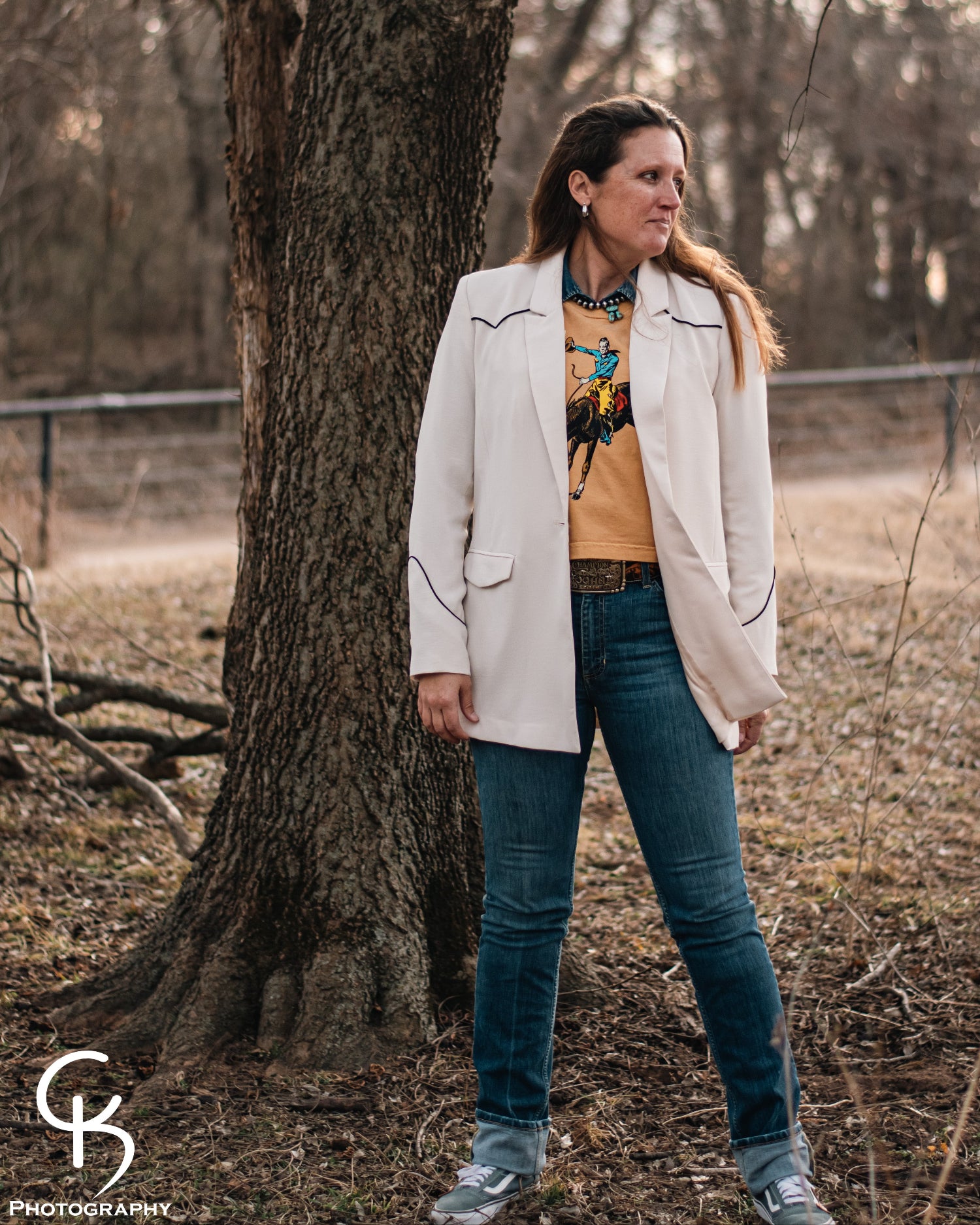 Model standing in trees, dressed in a stylish modern western outfit.