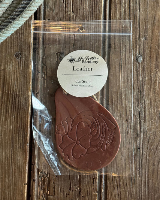 Brown leather stamp with a clear plastic cover on a wooden surface