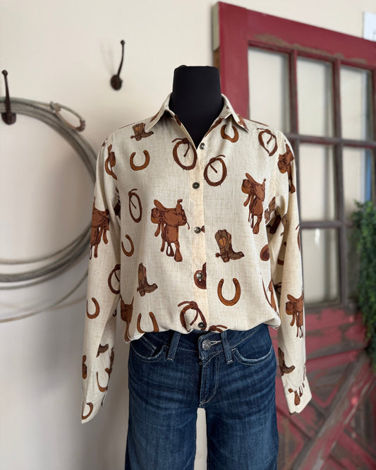 Mannequin wearing a white shirt with brown cowboy pattern and blue jeans against a neutral background.