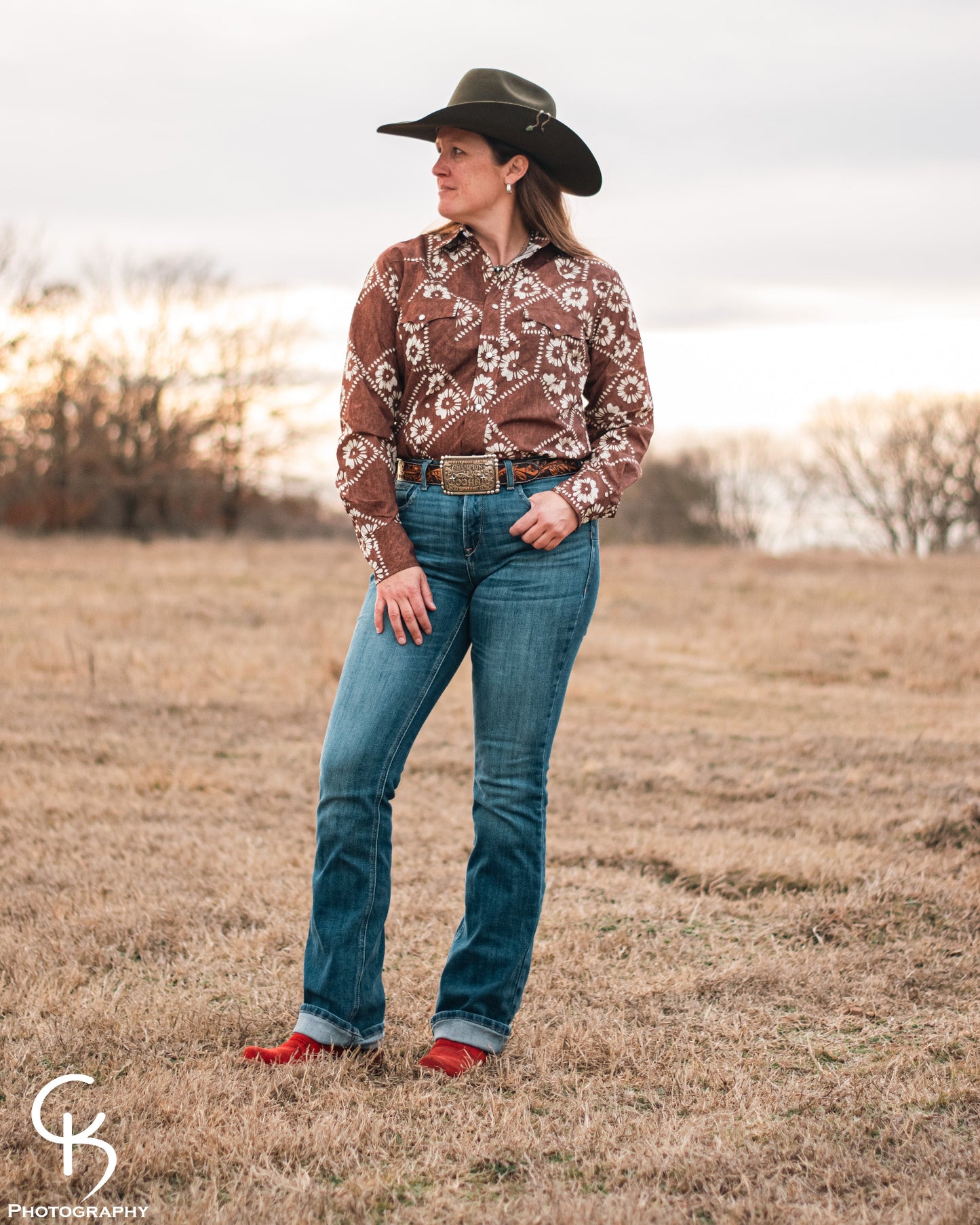 model standing in field wearing a fashionable modern western outfit