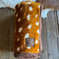 Folded blanket with brown and white pattern on a wooden surface