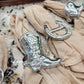 Silver cowboy boot and horseshoe napkin rings on beige fabric