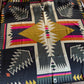 Colorful patterned scarf with geometric design on a wooden surface