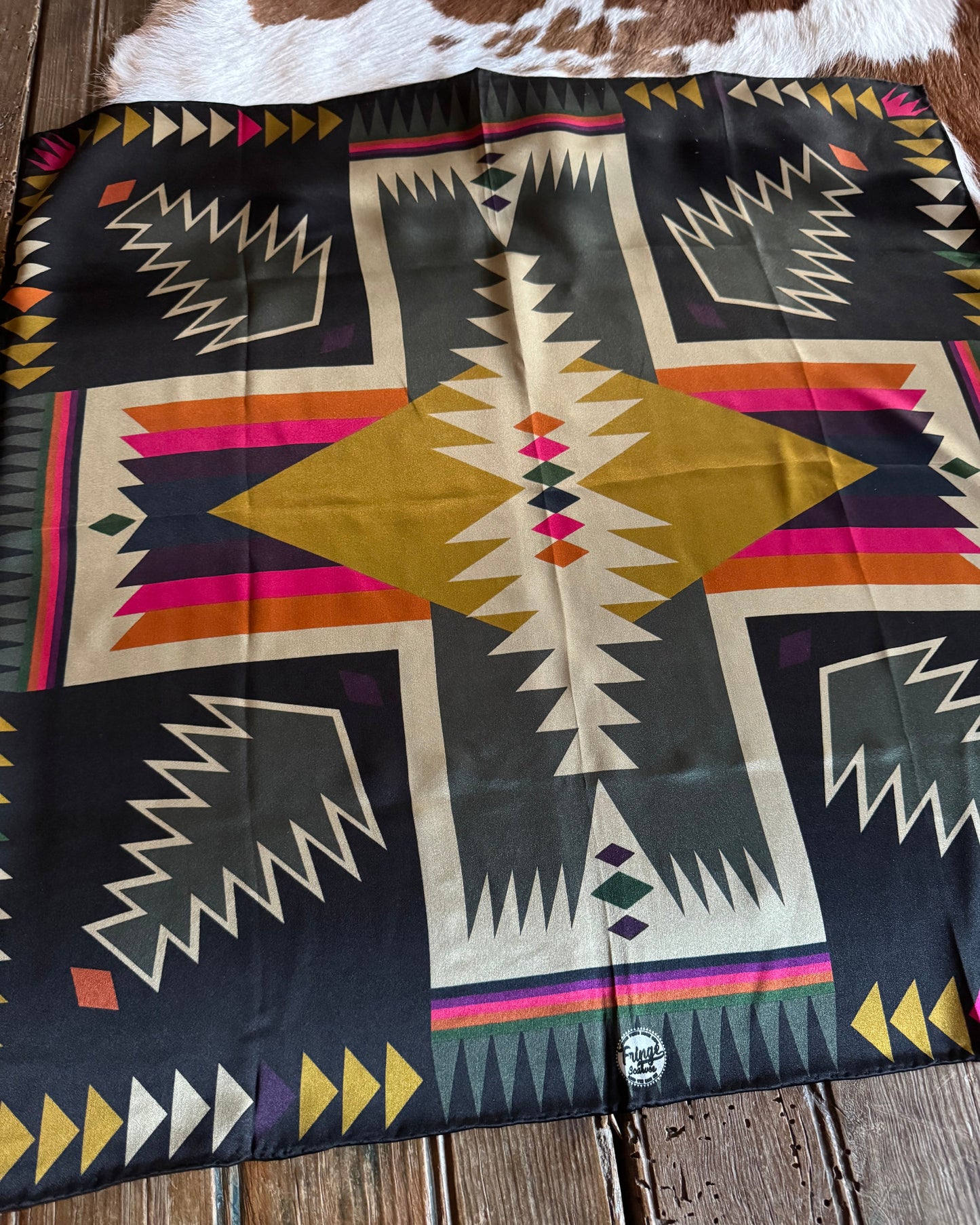 Colorful patterned scarf with geometric design on a wooden surface