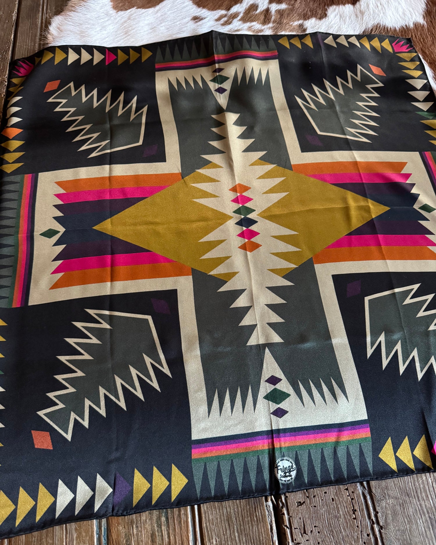 Colorful patterned scarf with geometric design on a wooden surface