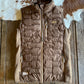 Brown quilted jacket on a wooden surface with cowhide rug