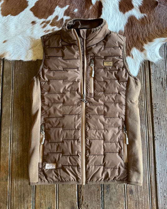 Brown quilted jacket on a wooden surface with cowhide rug