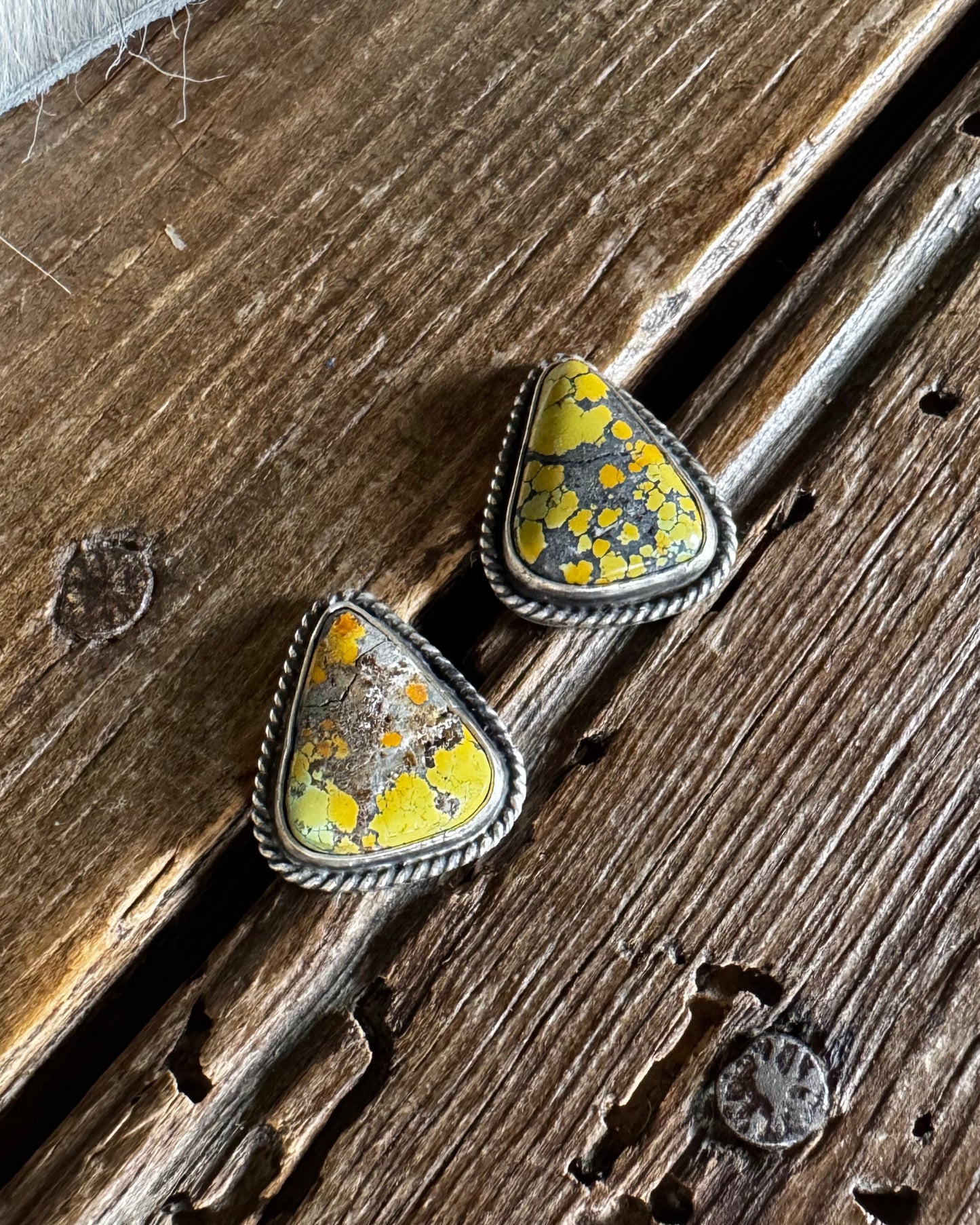 triangle stud earrings on a wooden surface