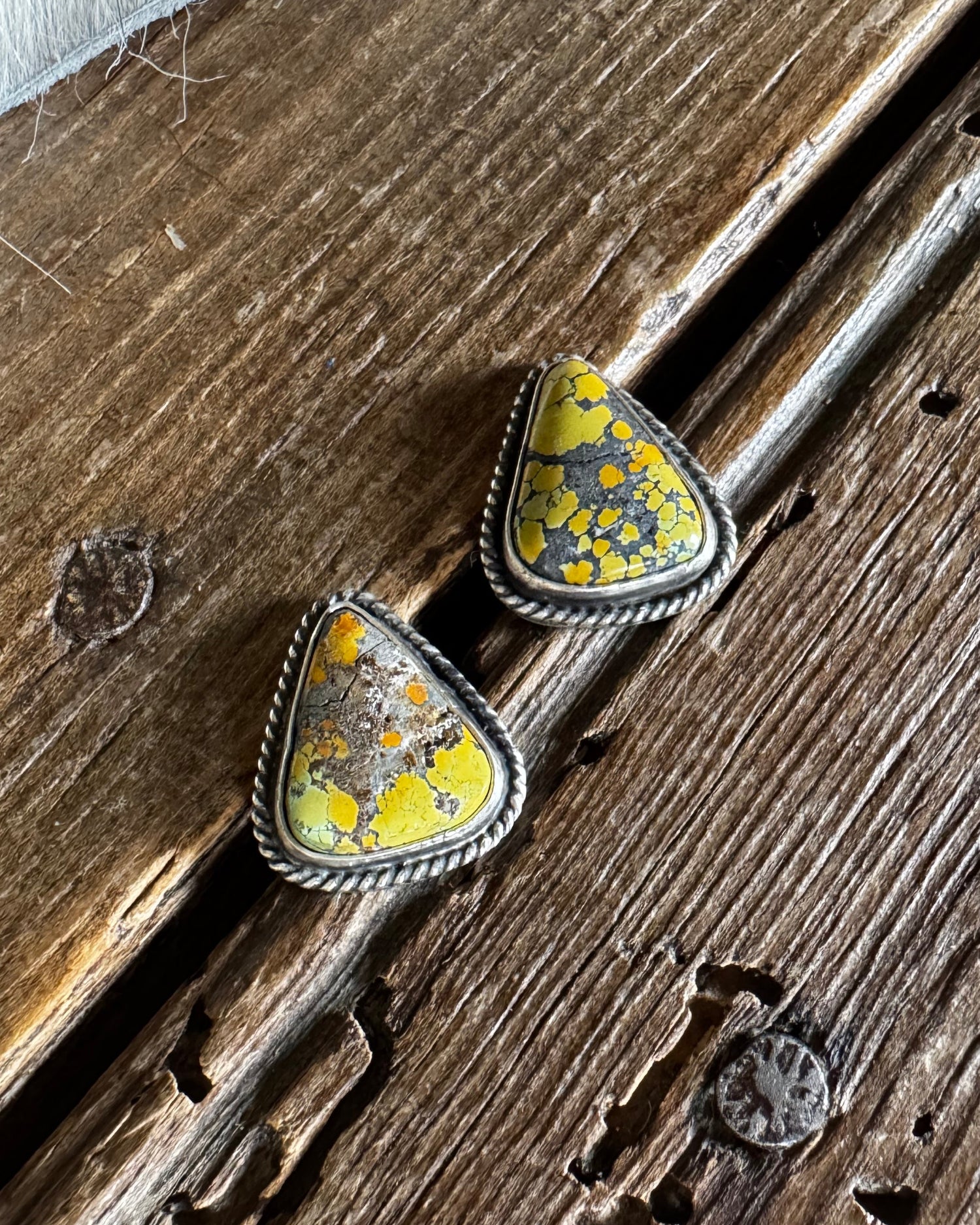 triangle stud earrings on a wooden surface