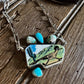 Necklace with a pendant featuring a landscape design on a wooden surface