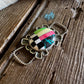 Twilly slide with a colorful pendant on a wooden surface