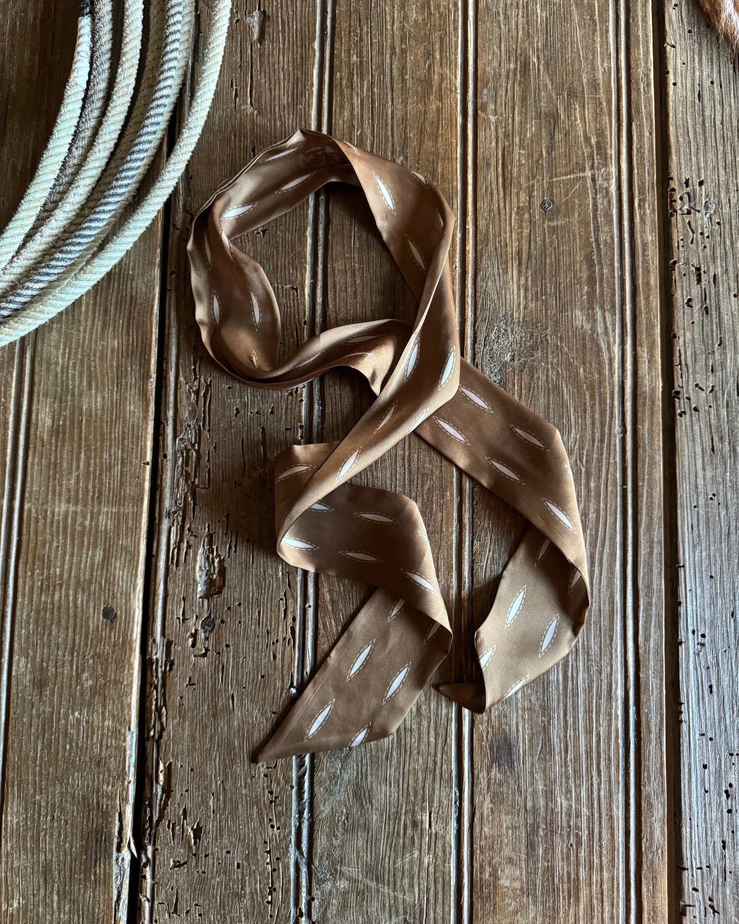 Brown ribbon scarf on a wooden surface
