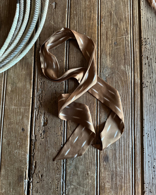 Brown ribbon scarf on a wooden surface