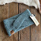 Blue knitted headband with a brand tag on a wooden surface