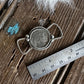 Decorative twilly slide on a wooden surface with a ruler for scale