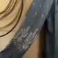 Blue denim shirt with white floral embroidery on a beige background