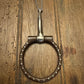 snaffle bit with chain on a wooden surface