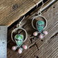 Pair of silver earrings with green and pink stones on a wooden surface with a ruler for scale.