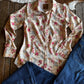 Floral shirt and blue jeans on a wooden surface with cowhide rug