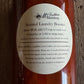 Bottle of laundry booster with a label on a wooden surface
