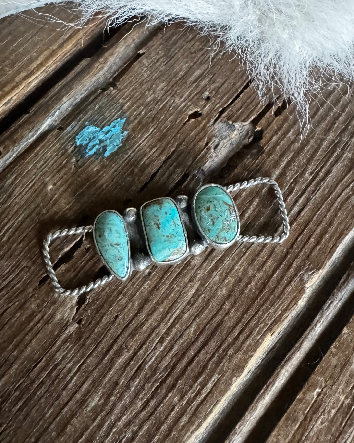 Turquoise stone twilly slide on a wooden surface