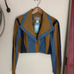 Brown and blue jacket on a white surface with a visible brand tag.