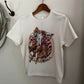 White t-shirt with a graphic design of a horse and text, hanging on a wooden hanger against a plain wall.