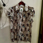 Floral patterned shirt on a hanger against a plain wall