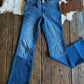 Blue jeans on a wooden floor with a cowhide rug in the background