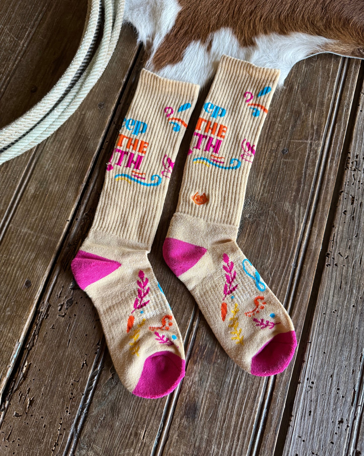Two socks with colorful designs on a wooden surface