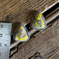 Pair of turquoise earrings on a wooden surface next to a ruler for scale