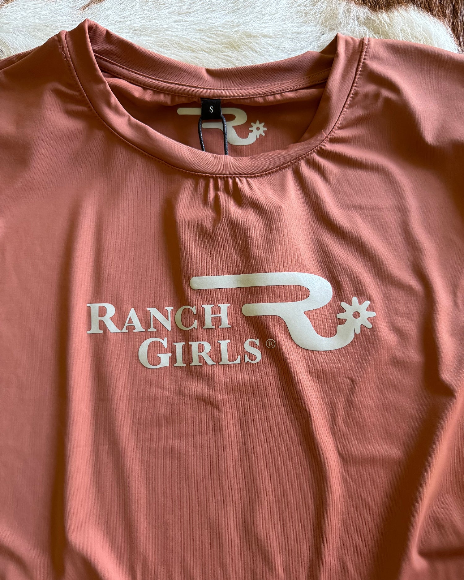 Dusty nude shirt with 'Ranch Girls' logo on a light background