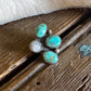 Turquoise stone ring on a wooden surface with white fur