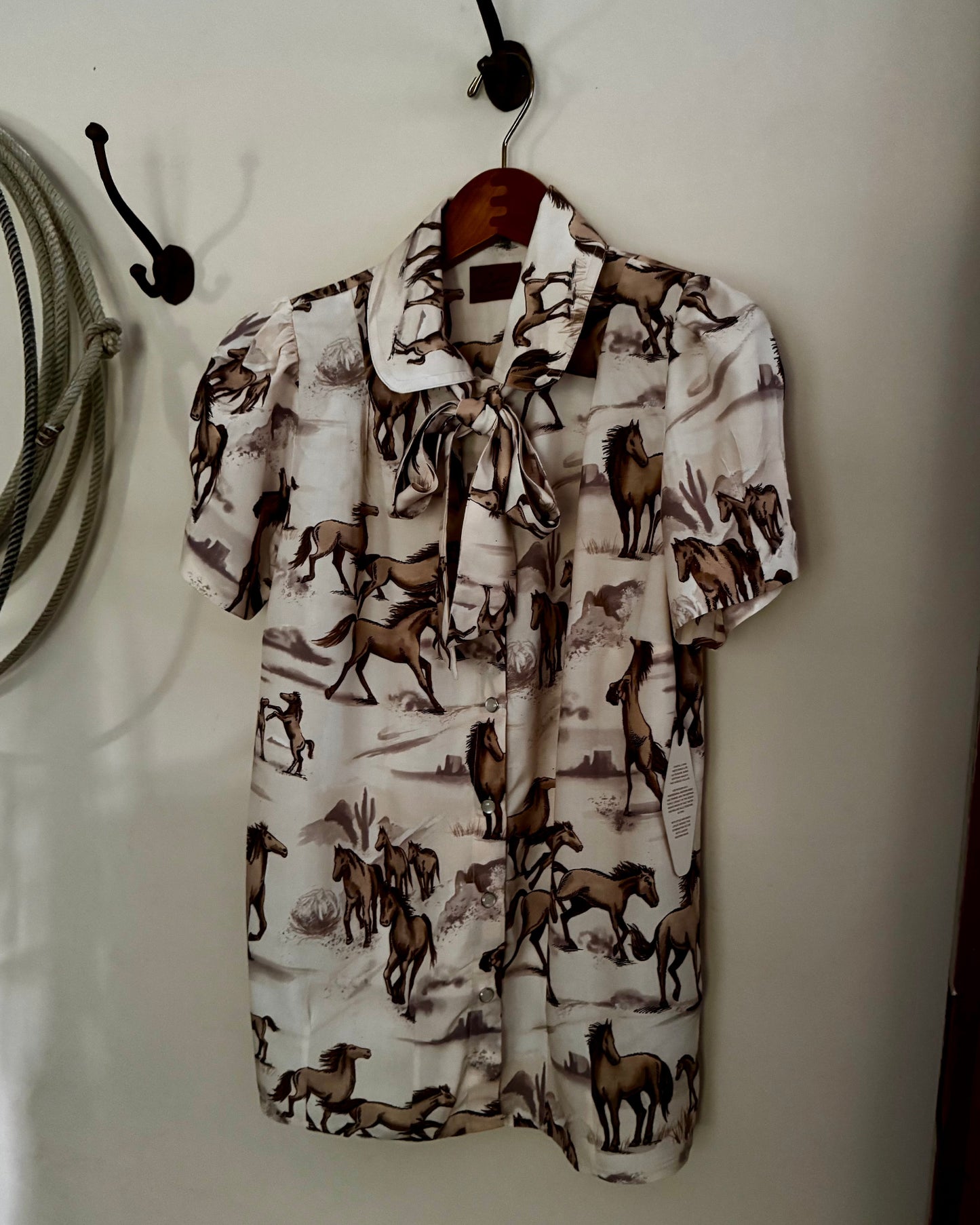 Short-sleeve shirt with horse pattern hanging on a wall