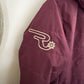 Close-up of a maroon jacket with a logo on a white background