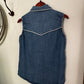 Blue denim dress on a white surface with a mirror and red object in the background