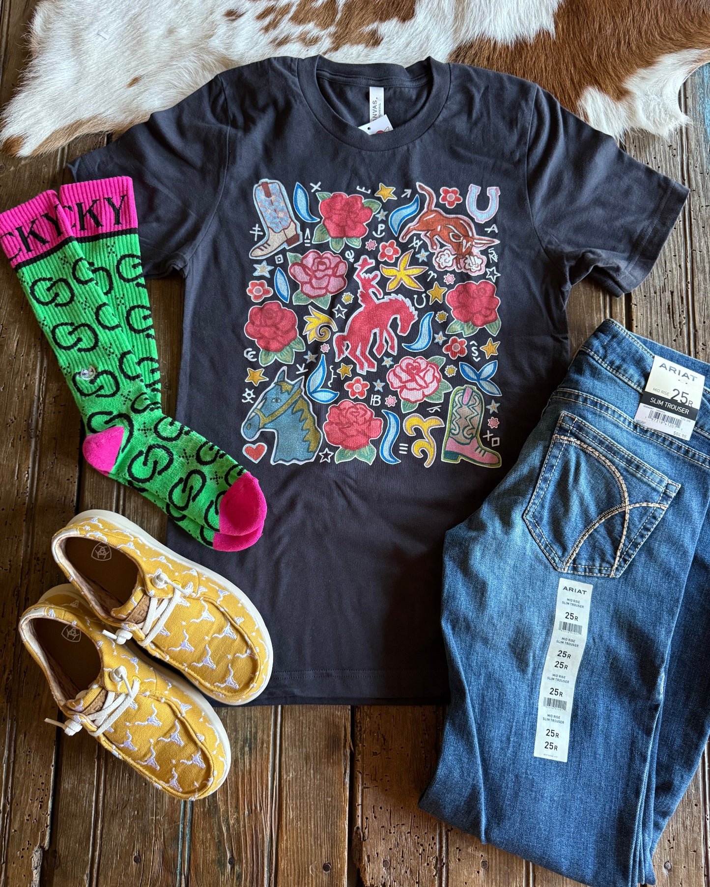 Western Rose Ranch Tee with jeans, socks and shoes on rustic wood background 