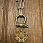 Vintage-style keychain with a brass lock charm on a wooden surface