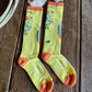 Pair of yellow socks with colorful designs on a wooden surface.