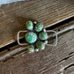 Jewelry with green stones and silver accents on a wooden surface