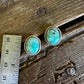 Turquoise earrings on a wooden surface with a ruler for scale.