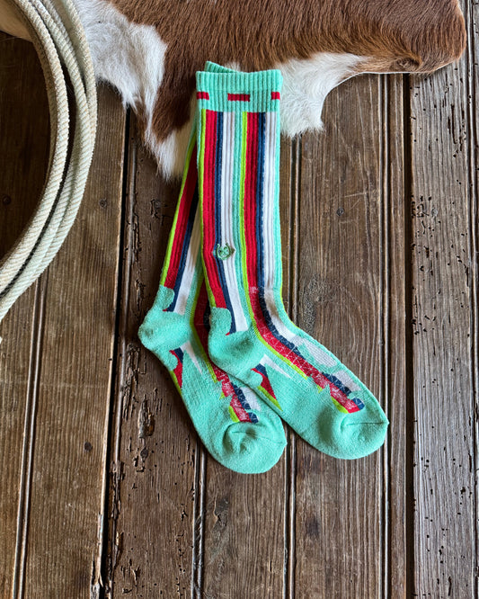 Pair of striped socks on a wooden surface with a cowhide