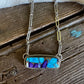 Necklace with a blue and purple stone on a wooden surface
