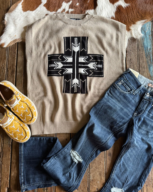 Cross sweater vest styled with jeans and shoes on rustic wood background 