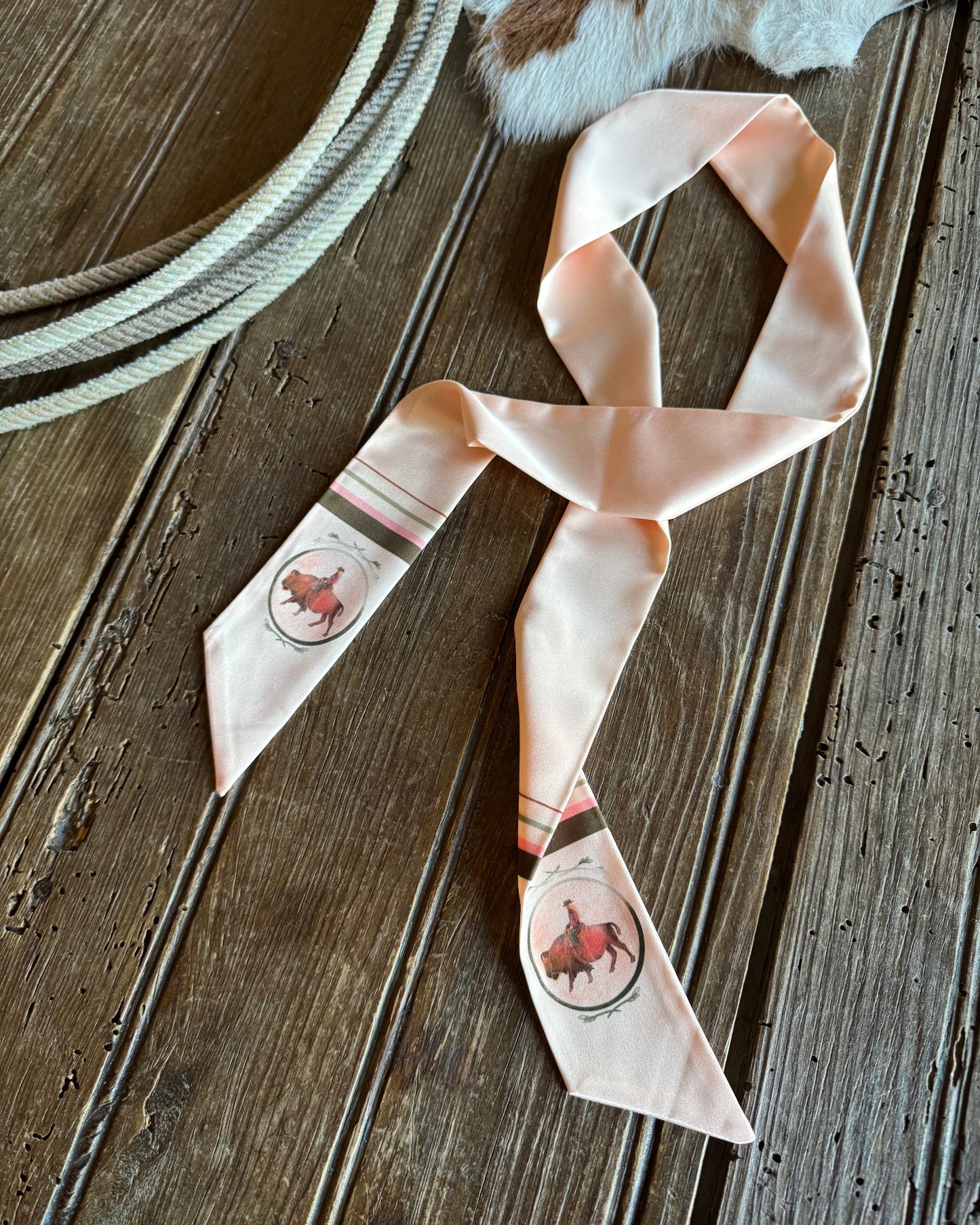 Ribbon scarf with buffalos with rustic wooden background and a rope 