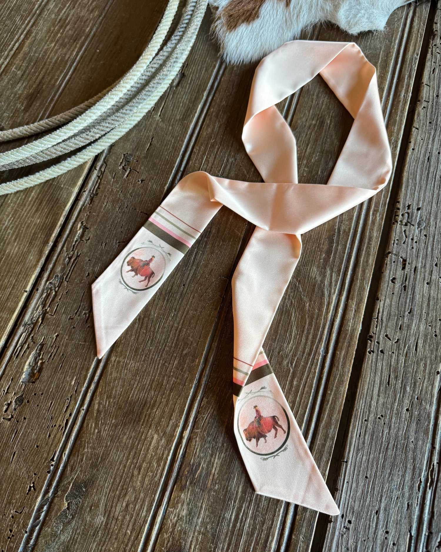 Ribbon scarf with buffalos with rustic wooden background and a rope 