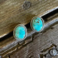 Turquoise stone earrings on a wooden surface