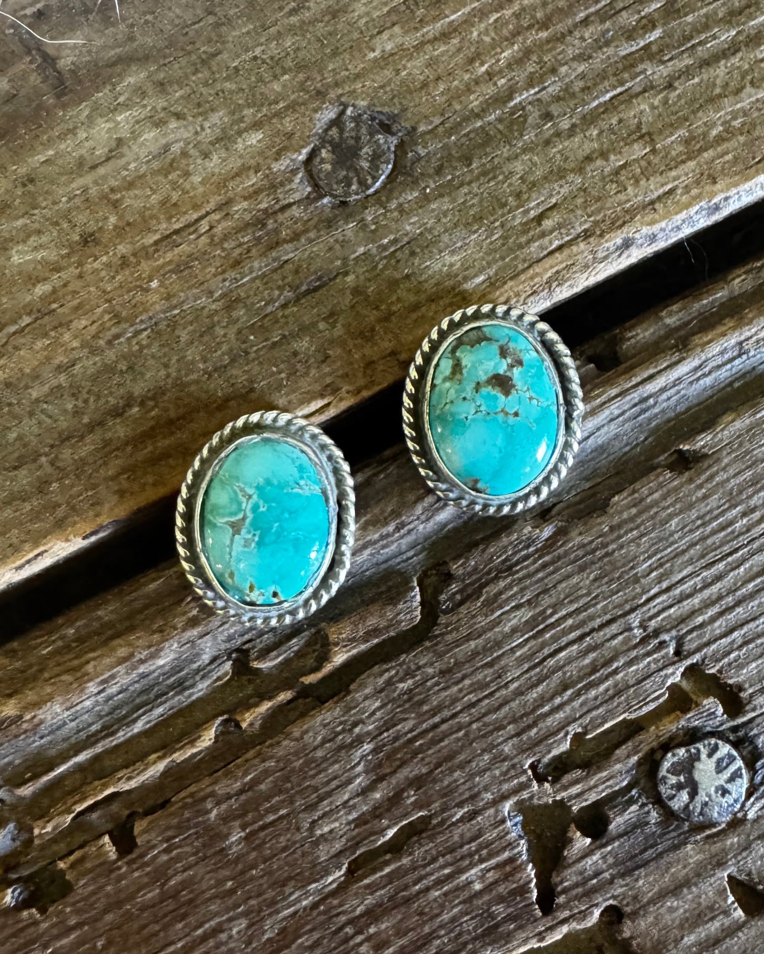 Turquoise stone earrings on a wooden surface