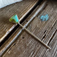 Necklace with a green triangle pendant on a textured surface